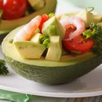 Avocado stuffed with shrimp salad macro on a plate. horizontal