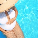 Beautiful pregnant woman in blue swimming pool